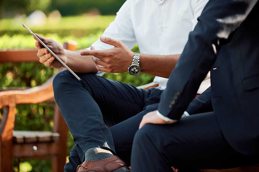 businessmen looking at tablet outside